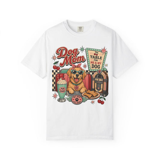 A white short-sleeve crewneck t-shirt featuring a colorful retro graphic of a dog wearing sunglasses, sitting in front of a jukebox and a sign that reads 'FOR TABLE FOR ME MY DOG'.