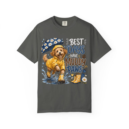 A dark gray short-sleeve t-shirt with a colorful graphic of a puppy in a yellow raincoat and hat under a daisy umbrella, next to the text 'BEST DAYS HAVE MUDDY PAWS'.